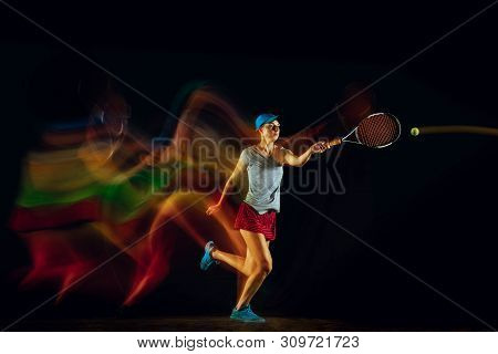 One Caucasian Woman Playing Tennis Isolated On Black Background In Mixed And Stobe Light. Fit Young 