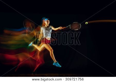 One Caucasian Woman Playing Tennis Isolated On Black Background In Mixed And Stobe Light. Fit Young 