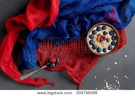 Healthy Food. Bowl Of Oatmeal With Blueberries, Spoon, Blue And Red Scarf On A Gray Table.