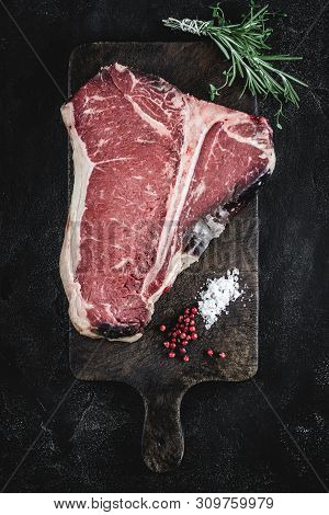 Dry Aged Beef Raw T-bone Steak On Vintage Cutting Board