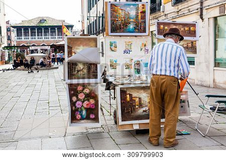 Venice, Italy - April, 2018: Senior Artist Selling His Paintings At The Santa Sofia Square In Venice