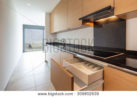 Light wood kitchen with dishwasher, stove and oven. No one inside. Elegant