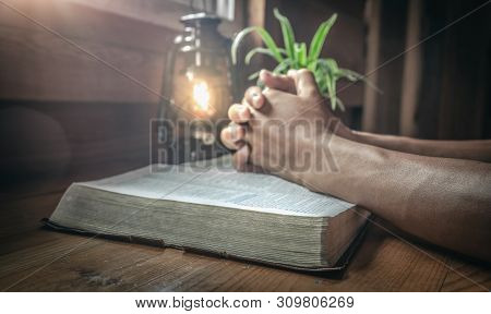 Close Up And Focus At Beside Of Old Bible With Hands Praying On The Bible Background.