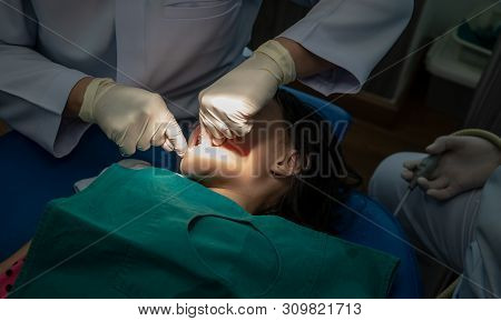 Asian Girl Met The Dentist For Routine Dental Checkup And Consultant. Dental Cleaning Process.