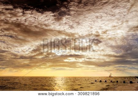 beautiful sailboat sailing on sea over dramatic sunset sky in Florida, USA