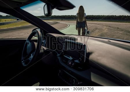 Girl On The Race Track. Holding Helmet