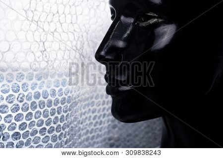 Profile Portrait Of Black Woman Mannequin With White Burble Wrap Plastic Fashion Background