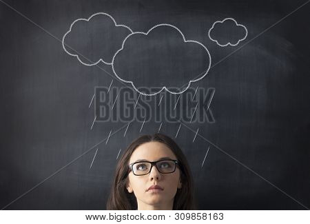 Young Woman In Bad Mood With Clouds And Rain Above Head