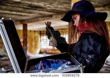Girl In A Black Cloak With A Diplomat And Money In A Ruined Room. A Spy In A Secret Meeting. Unusual