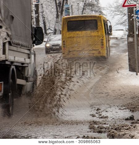 The Car B Stro Drives Through A Puddle Of Dirt, Sprays Fly From Under The Wheels