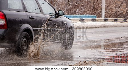 The Car B Stro Drives Through A Puddle Of Dirt, Sprays Fly From Under The Wheels