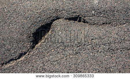 There Are Many Potholes On The Roadway Close Up
