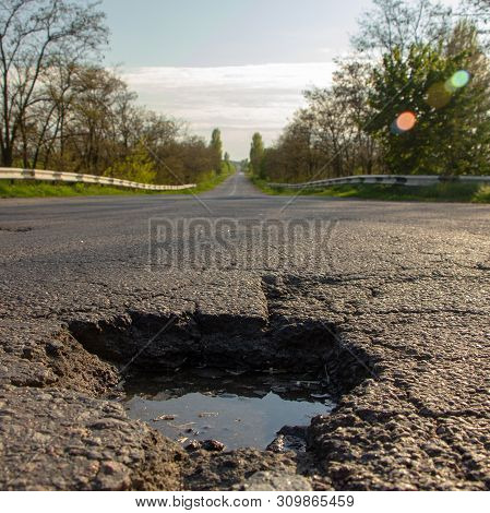There Are Many Potholes On The Roadway Close Up