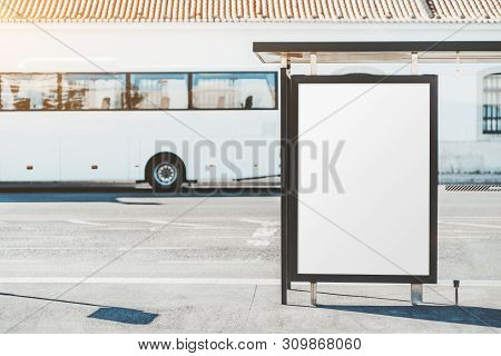 The Bus Stop With A Departing White Bus In The Background And With Blank Poster Mock-up Inside; An A