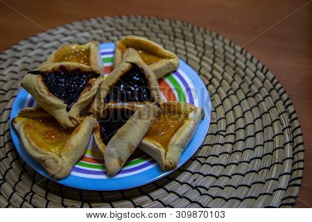 Hamantash Purim Blueberry And Apricot Jam Cookies In Colored Plate With Wooden Table Background