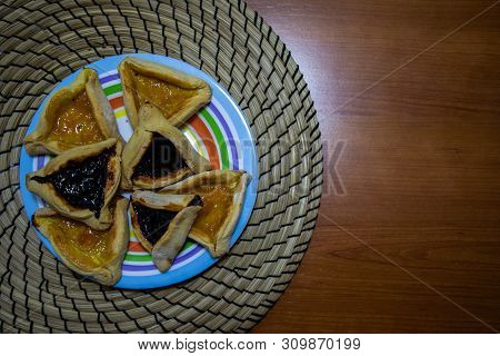 Hamantash Purim Blueberry And Apricot Jam Cookies In Colored Plate With Wooden Table Background