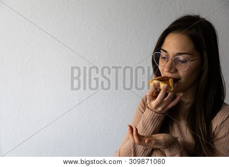 Beautiful And Happy Women Portrait Eating Hamantash Purim Apricot Cookie