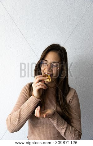 Beautiful And Happy Women Portrait Eating Hamantash Purim Apricot Cookie