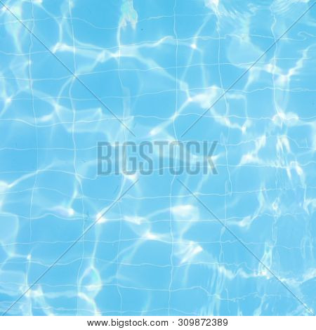 Water Vibrations In The Swimming Pool With Sun Reflection. Blue Swimming Pool Surface, Water Backgro