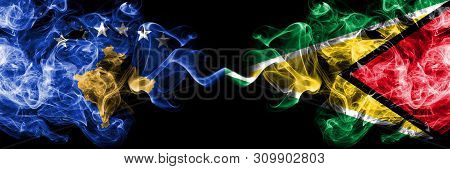 Kosovo Vs Guyana, Guyanese Smoky Mystic Flags Placed Side By Side. Thick Colored Silky Smokes Combin