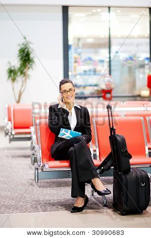 Genç işkadını havaalanında cep telefonuyla konuşuyor