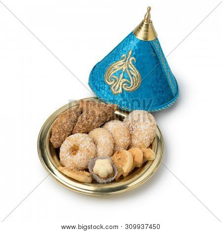 Traditional Moroccan festive cookies in a festive metal tajine isolated on white background