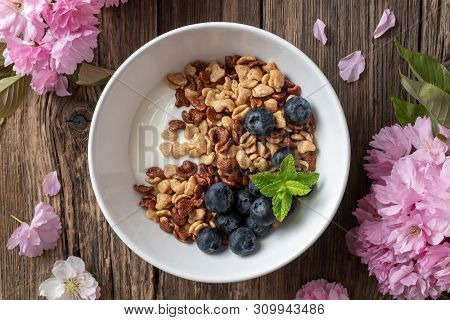 Breakfast Cereals With Yogurt And Blueberries, With Pink Kwanzan Cherry Blossoms