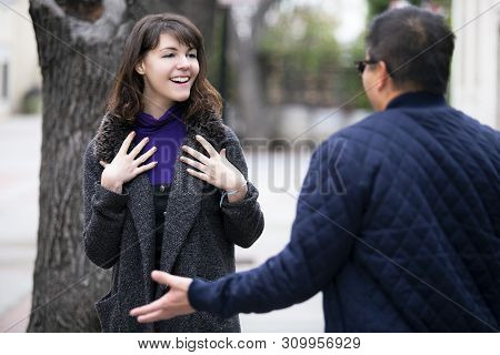 Female Pedestrian Walking Into A Friend By Coincidence On The Street.  They Are Meeting And Greeting