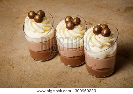 Closeup Three Small Plastic Cups With Three-layered Mousse Dessert
