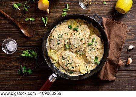 Chicken Breast In Creamy Garlic Sauce In Cast Iron Pan Over Wooden Background. Healthy Diet Food. To