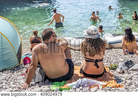 Vis, Croatia - Aug 17, 2020: Tourists Sunbathing On Sheltered Cove Stiniva Beach In Summer