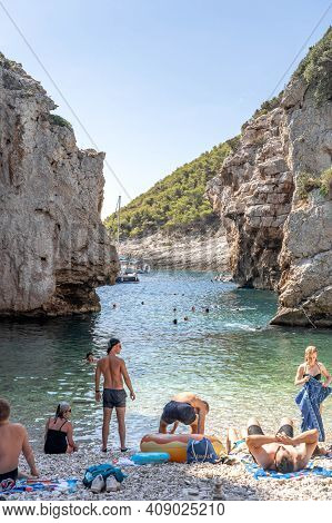 Vis, Croatia - Aug 17, 2020: Tourists Sunbathing On Sheltered Cove Stiniva Beach In Summer