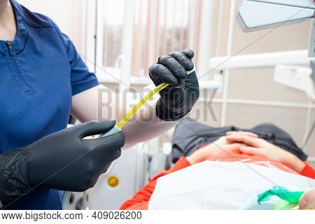 Dental Assistant Helping With Saliva Ejector During Dentist Treatment