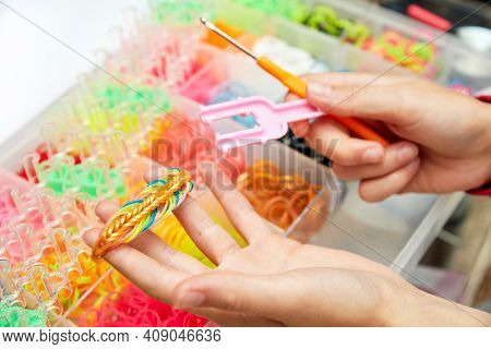 Rubber Band Weaving. Knitting Rubber Bands With Loom Knit. Hands Of Girl Hold A Wristband Of Rubber 