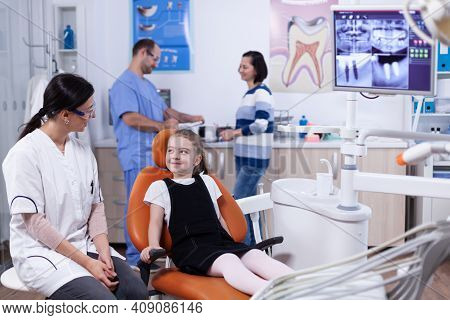 Little Girl In Stomatology Office Waiting For Her Teeth Medical Procedure And Examination. Child Wit