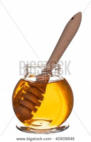 Pot met honing met houten drizzler geïsoleerd op witte achtergrond