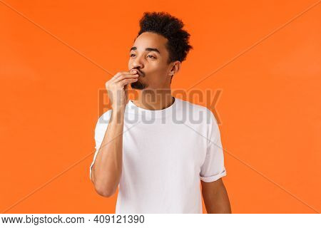 Magnifico. Impressed And Delighted African-american Guy With Moustache And Afro Haircut, Kissing Fin