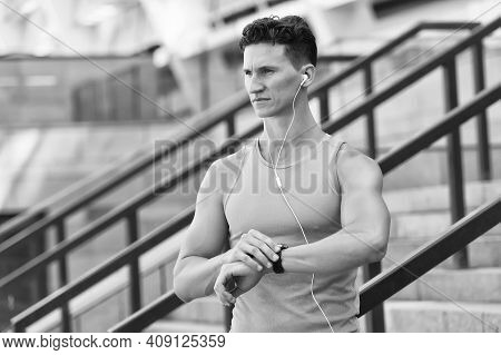 Training And Lifestyle Concept. Runner With Heart Rate Monitor Sports Smart Watch. Looking At Watch.