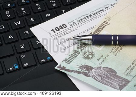 Us Irs Internal Revenue Service Income Tax Filing Form 1040 With Pen On Keyboard.