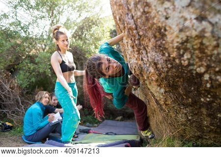Friends Go In For Sports In Nature, Bouldering On Rocks, Girl Climbs A Big Stone, Woman Is Belayng P
