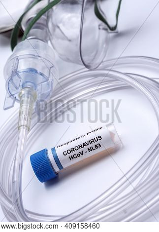 Vial With Sars-cov-2 Coronavirus Sample Next To An Oxygen Mask In A Hospital, Conceptual Image