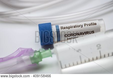 Vial With Sars-cov-2 Coronavirus Sample Next To An Oxygen Mask In A Hospital, Conceptual Image