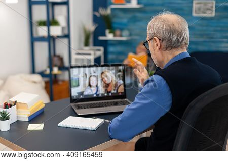 Old Parent Greenting Daughter During Video Conference On Portable Computer. Happy Grandfather Saying