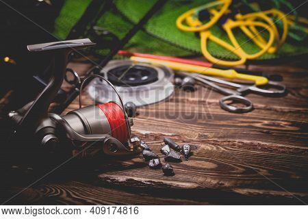 Fishing Tackle On A Wooden Background. Studio Photo With Vignetting.