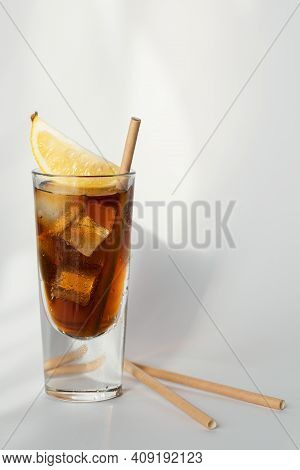 Glass Of Cola With Ice, Lemon And Straw On White Background