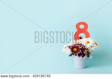 Number 8 With Bouquet Of Flowers On Blue Background With Copy Space. Spring Card For Woman