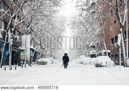 Madrid - January 9, 2021: Small Groups Of People Walk In The Snow Along A Commercial Street In Madri