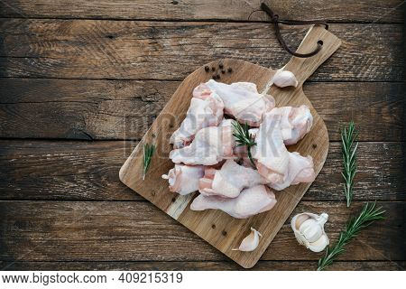 Raw Chicken Wings On Cutting Board With Ingredients For Cooking At Wooden Kitchen Table. Fresh Uncoo