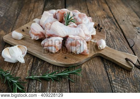 Raw Buffalo Of Chicken Wings On Cutting Board With Ingredients For Cooking On Wooden Background. Fre