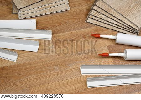 Set Of Items For Pvc Ceiling Indoor Works. Assembly Adhesive Bottles And Pvc Panels With Plastic Cor